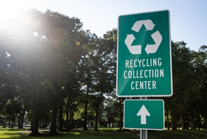 A road sign leads to a recycling collection center.